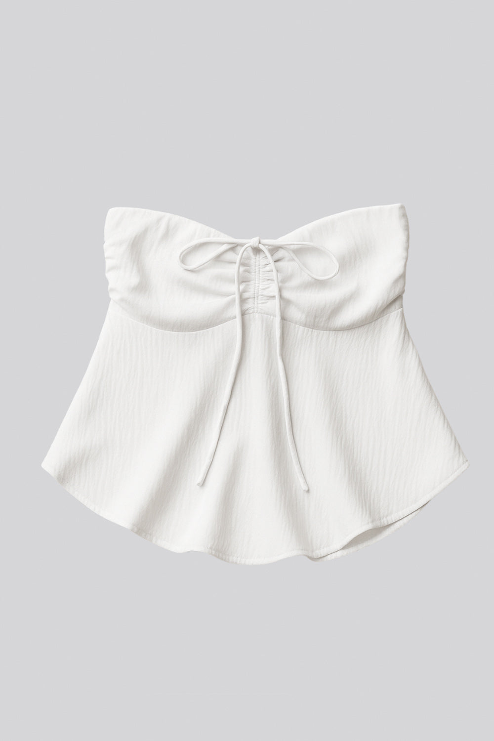 Top corto halter con lazo amarrable posterior, escote corazón con jareta ajustable y plisados frontales. Detalle de peplum con olanes y fruncido en espalda.