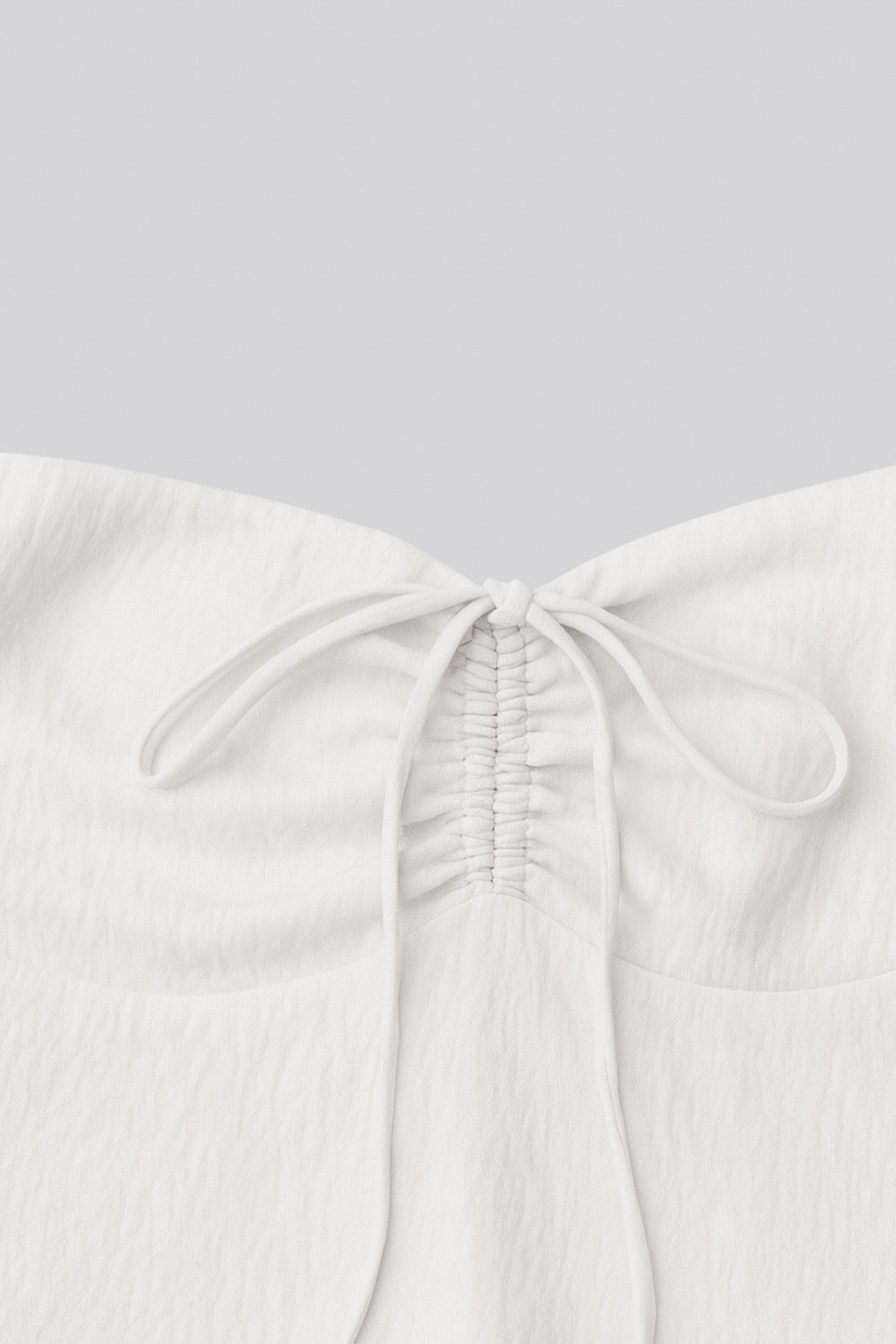 Top corto halter con lazo amarrable posterior, escote corazón con jareta ajustable y plisados frontales. Detalle de peplum con olanes y fruncido en espalda.