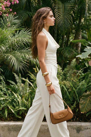 Top de cuello halter con escote fluido, fit ajustado, sin mangas y escote en espalda con plisados.