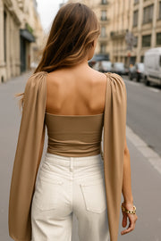 Top de fit ajustado, sin mangas, cuello redondo y detalle decorativo frontal con plisados en hombros.