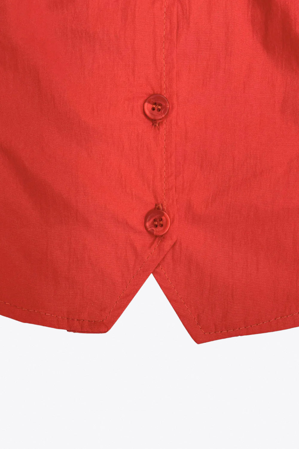 Top corto de fit recto, sin mangas, cuello redondo, bajo v frontal y cierre con hilera de botones.