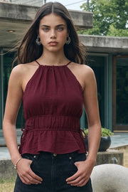 Top corto de cuello halter con tirantes delgados, fit ajustado, rib con plisados en cintura y cuello. Detalle de jaretas ajustables en cintura, cierre posterior con botón y ojal.