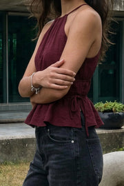 Top corto de cuello halter con tirantes delgados, fit ajustado, rib con plisados en cintura y cuello. Detalle de jaretas ajustables en cintura, cierre posterior con botón y ojal.