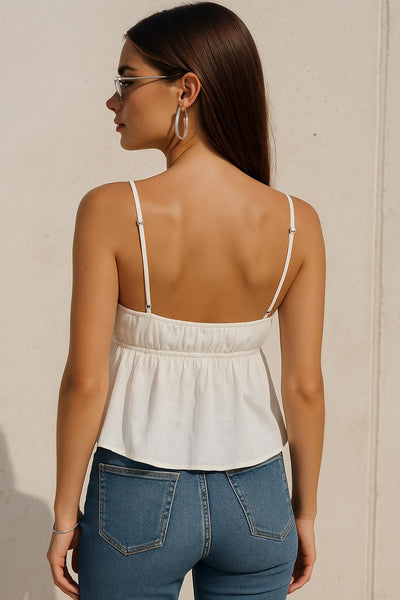 Top corto de tirantes delgados ajustables, escote v con cortes y plisados decorativos, peplum con olanes en bajo y rib elástico posterior.