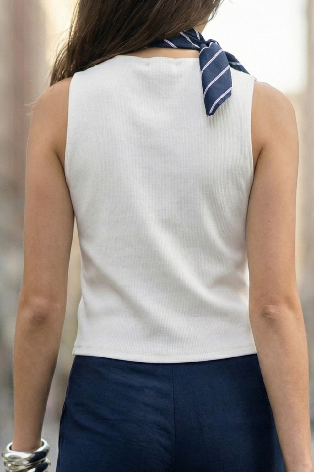 Chaleco canalé de punto, fit ajustado, escote redondo y cierre frontal con hilera de botones en contraste. Detalle de bajo v frontal.