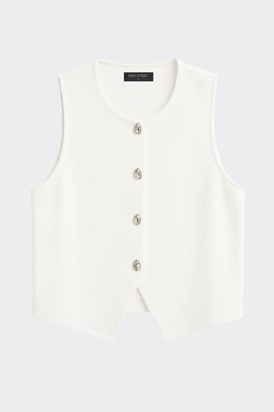 Chaleco canalé de punto, fit ajustado, escote redondo y cierre frontal con hilera de botones en contraste. Detalle de bajo v frontal.