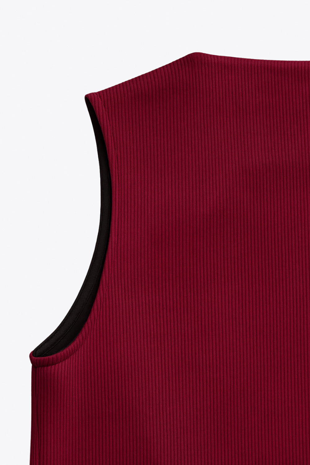 Chaleco canalé de punto, fit ajustado, escote redondo y cierre frontal con hilera de botones en contraste. Detalle de bajo v frontal.