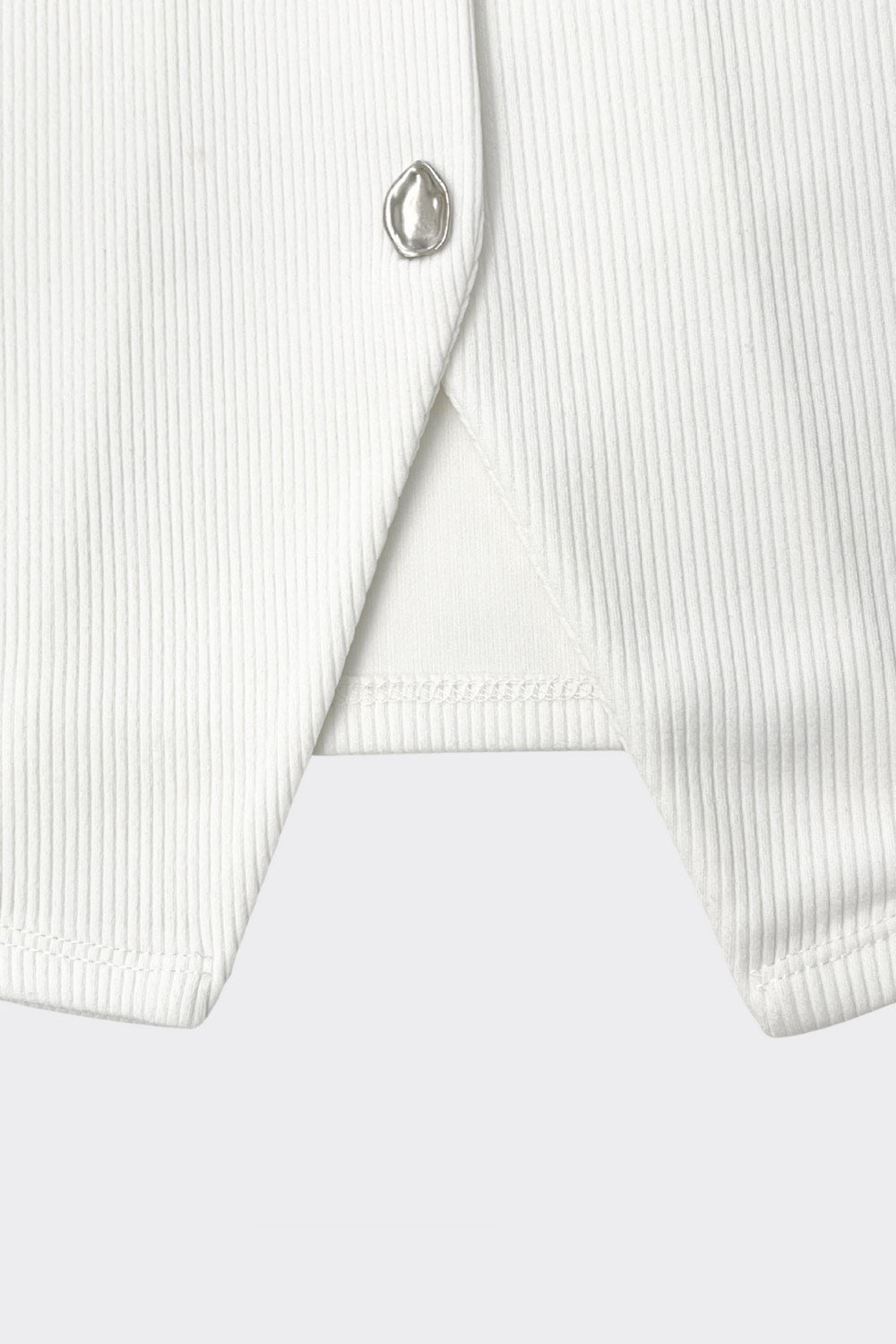 Chaleco canalé de punto, fit ajustado, escote redondo y cierre frontal con hilera de botones en contraste. Detalle de bajo v frontal.