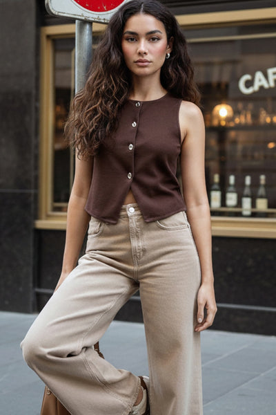 Chaleco corto de fit recto, cuello redondo y cierre frontal con hilera de botones en contraste. Detalle abertura v en bajo.