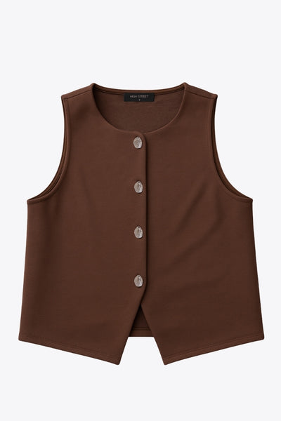 Chaleco corto de fit recto, cuello redondo y cierre frontal con hilera de botones en contraste. Detalle abertura v en bajo.