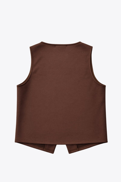 Chaleco corto de fit recto, cuello redondo y cierre frontal con hilera de botones en contraste. Detalle abertura v en bajo.