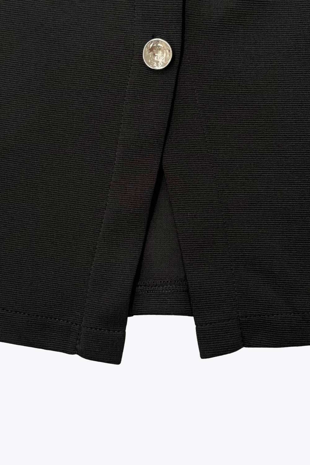 Chaleco de punto, fit ajustado, cortes frontales, cuello redondo y cierre frontal con hilera de botones en contraste.