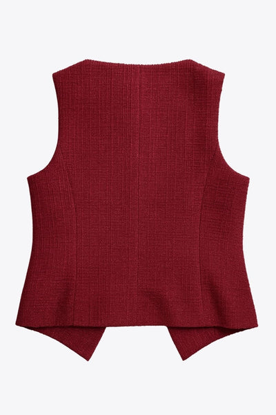 Chaleco corto de bouclé, fit recto, cuello barco y cierre frontal con hilera de botones en contraste. Detalle abertura v en bajo y vivos decorativos frontales.