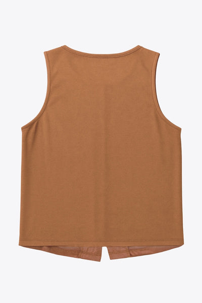 Chaleco corto de gamuza, fit recto, cuello redondo y cierre frontal con hilera de botones en contraste. Detalle de abertura frontal en bajo.