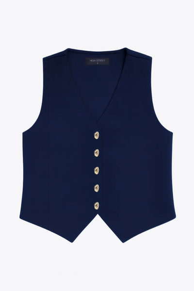 Chaleco de punto, fit recto, escote v y cierre frontal con hilera de botones en contraste. Detalle de bajo v frontal.