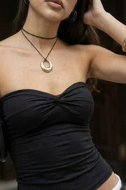 Top corto strapless, fit ajustado, escote corazón con nudo frontal y plisados decorativos.