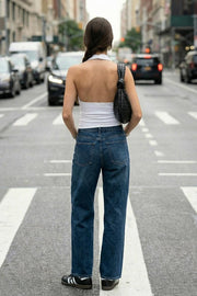 Top corto ajustado de cuello halter con escote fluido, sin mangas, escote en espalda, cierre posterior con botón y ojal.