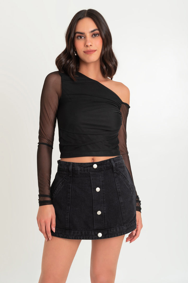 Woman in a stylish one-shoulder top and black denim skirt.