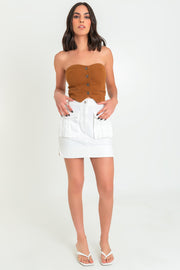 Top corto strapless de fit ajustado, cortes decorativos frontales, escote corazón y cierre frontal con hilera de botones en contraste. Detalle de vivos decorativos frontales.