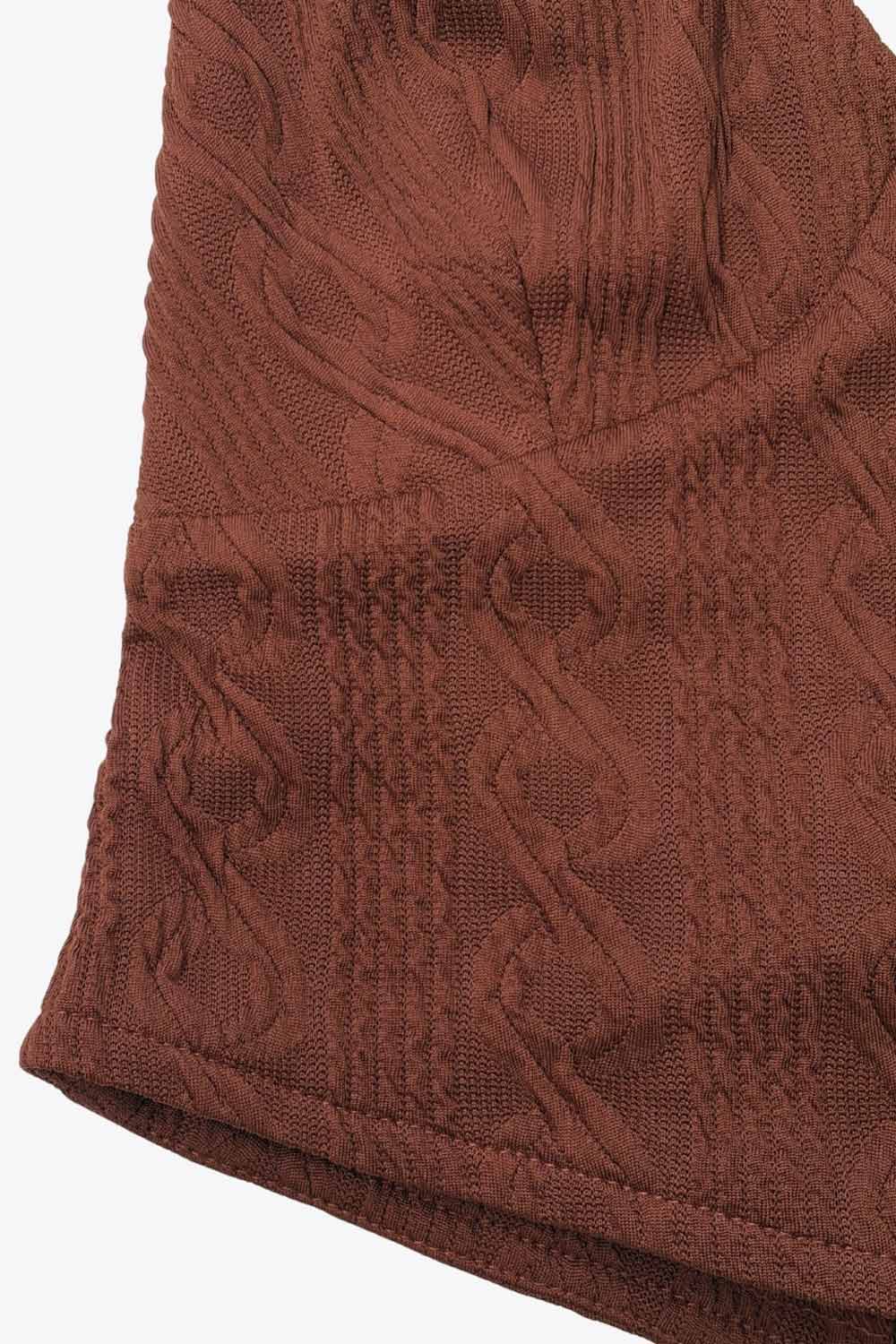 Top corto de cuello halter, lazo amarrable posterior, escote v con cortes frontales, bajo v frontal, escote en espalda y lazo amarrable posterior. Detalle de textura en tejido.