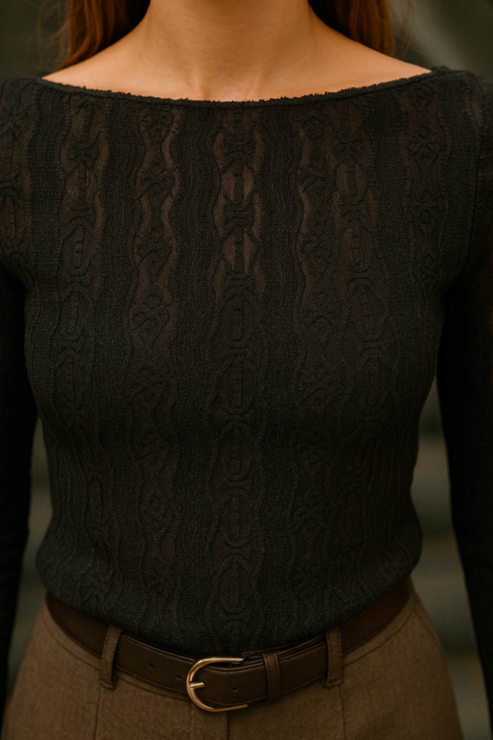 Top de encaje, fit ajustado, cuello barco, manga larga y bajo asimétrico.