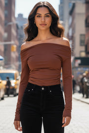 Top de fit ajustado, hombros descubiertos, escote recto y manga larga seguida con plisados laterales. Detalle de plisados en costados.