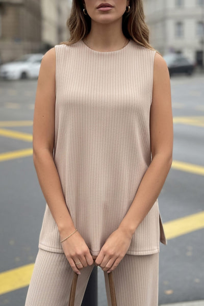 Top canalé de punto, fit fluido, cuello redondo, sin mangas y detalle de aberturas laterales en bajo.
