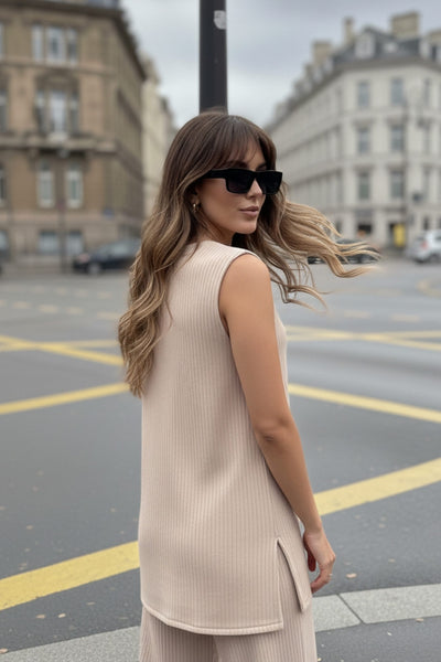 Top canalé de punto, fit fluido, cuello redondo, sin mangas y detalle de aberturas laterales en bajo.
