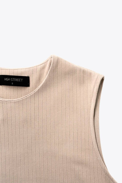 Top canalé de punto, fit fluido, cuello redondo, sin mangas y detalle de aberturas laterales en bajo.