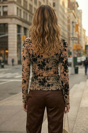 Top de mesh con estampado floral, cuello barco y manga larga. Detalle de rib en bordes.