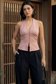 Top corto de cuello halter con nudo amarrable posterior, escote v con cortes y plisados decorativos frontales, fit ajustado, escote en espalda con fruncido posterior, cierre frontal con hilera de botones y bajo curveado con abertura.