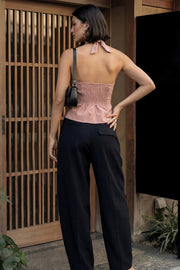Top corto de cuello halter con nudo amarrable posterior, escote v con cortes y plisados decorativos frontales, fit ajustado, escote en espalda con fruncido posterior, cierre frontal con hilera de botones y bajo curveado con abertura.