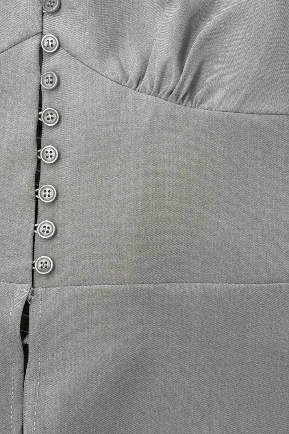 Top corto de cuello halter con nudo amarrable posterior, escote v con cortes y plisados decorativos frontales, fit ajustado, escote en espalda con fruncido posterior, cierre frontal con hilera de botones y bajo curveado con abertura.