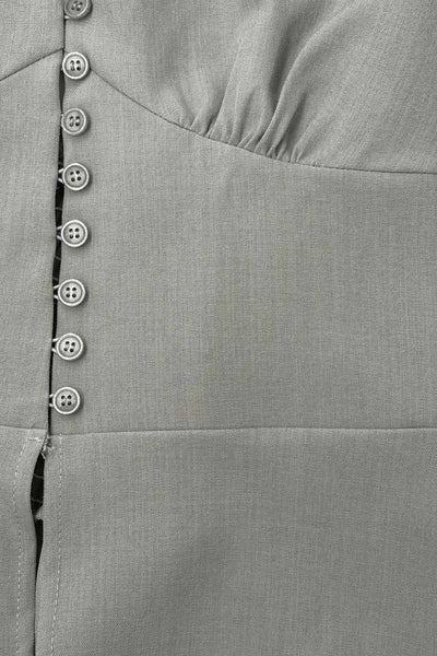 Top corto de cuello halter con nudo amarrable posterior, escote v con cortes y plisados decorativos frontales, fit ajustado, escote en espalda con fruncido posterior, cierre frontal con hilera de botones y bajo curveado con abertura.