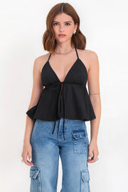 Top corto halter de escote v con lazo amarrable frontal, rib elástico en espalda, tirantes halter con lazo amarrable posterior y abertura frontal en bajo. Detalle de peplum olanes y textura en tejido.