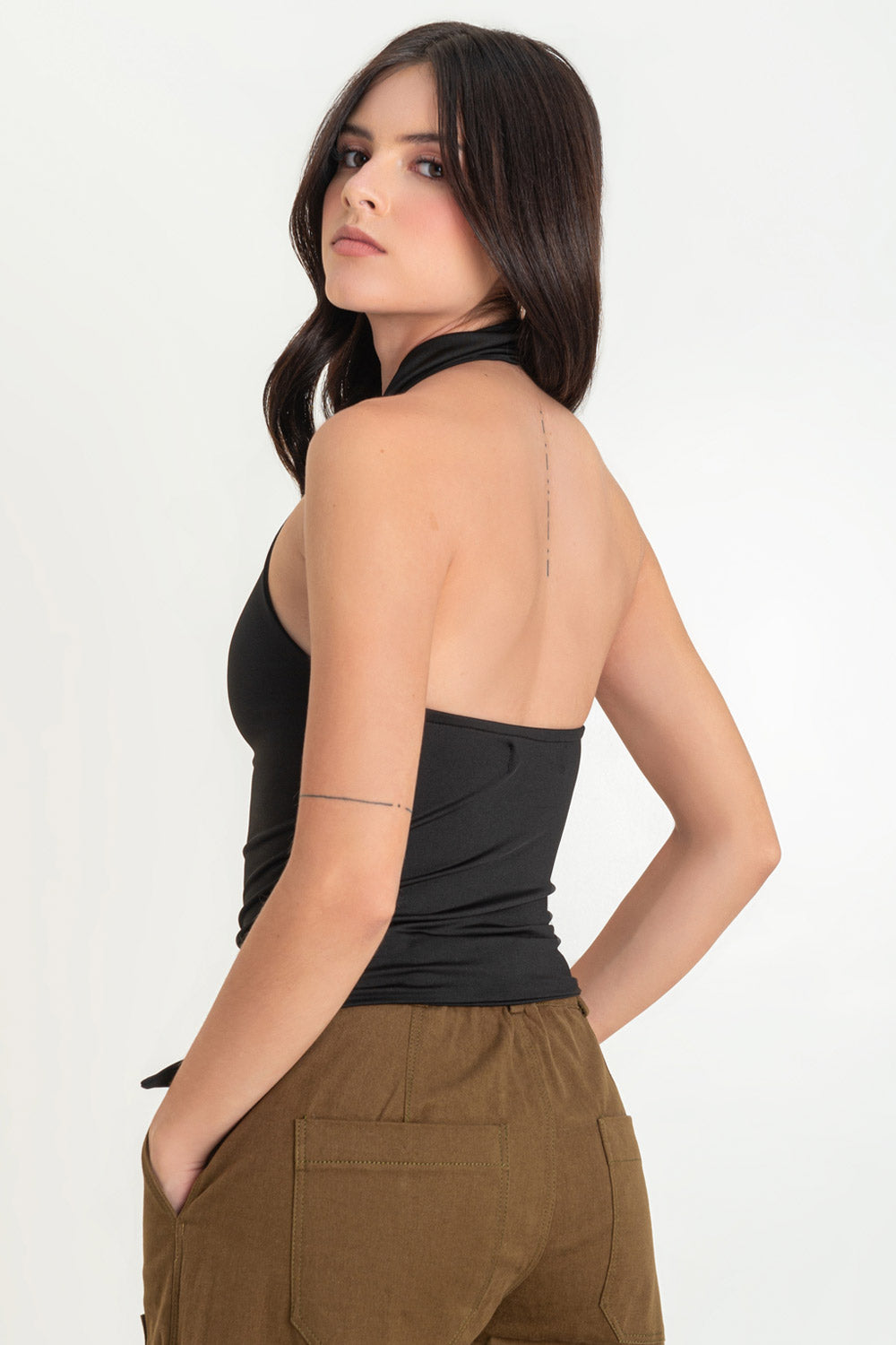 Top halter de fit ajustado, cuello alto fluido, sin mangas y bajo diagonal asimétrico.