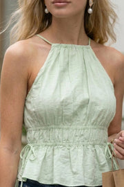 Top corto de cuello halter con tirantes delgados, fit ajustado, rib con plisados en cintura y cuello. Detalle de jaretas ajustables en cintura, cierre posterior con botón y ojal.