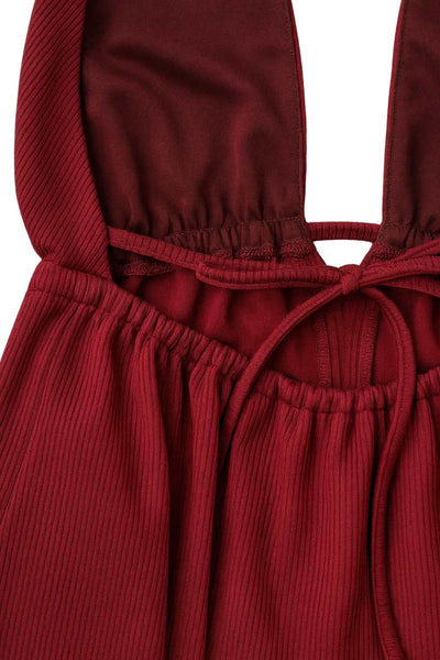 Top canalé de cuello halter con nudo amarrable posterior, escote v con plisados frontales, rib elástico en cintura y peplum olanes. Detalle de escote en espalda con lazo amarrable posterior.