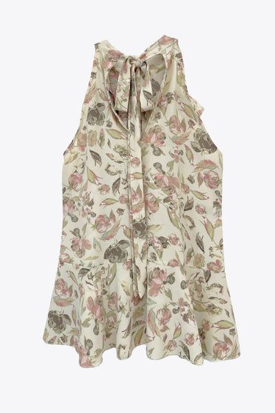 Blusa de fit fluido, estampado floral, sin mangas, cuello halter, capas de olanes frontales y en bajo asimétrico. Cierre posterior con lazo amarrable.