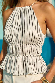 Top corto de estampado rayas, cuello halter con tirantes delgados, fit ajustado, rib con plisados en cintura y cuello. Detalle de jaretas ajustables en cintura, cierre posterior con botón y ojal.