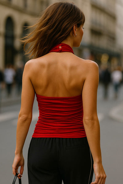 Top halter de fit ajustado, cuello alto fluido, sin mangas, plisados en costados y cierre posterior con botón y ojal.