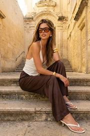 Top halter de fit ajustado, escote v con cortes y plisados frontales, plisados en costado, tirantes delgados halter con nudo amarrable posterior, escote espalda y bajo v frontal.