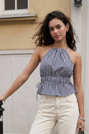 Top corto de estampado cuadros, cuello halter con tirantes delgados, fit ajustado, rib con plisados en cintura y cuello. Detalle de jaretas ajustables en cintura, cierre posterior con botón y ojal.