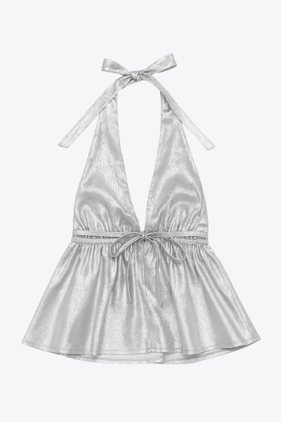 Top corto metálico de cuello halter con tirantes y nudo amarrable posterior, peplum con olanes, rib elástico en cintura y lazo amarrable posterior.