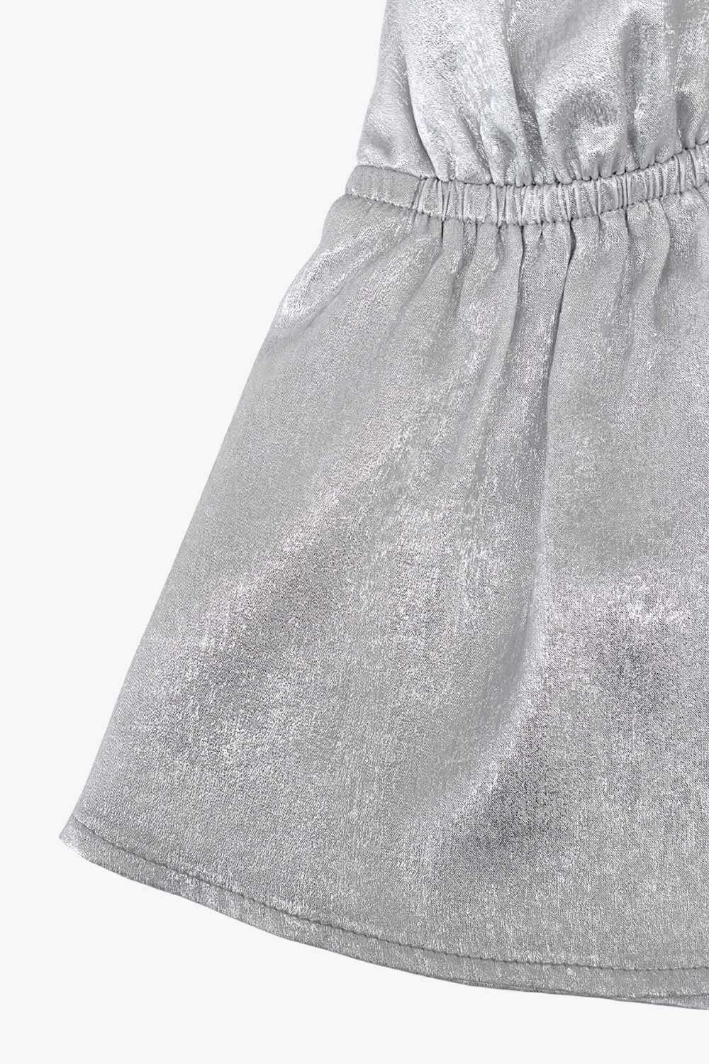 Top corto metálico de cuello halter con tirantes y nudo amarrable posterior, peplum con olanes, rib elástico en cintura y lazo amarrable posterior.