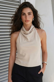Top de cuello halter fluido, escote en espalda con lazo amarrable posterior, cierre con botón y ojal.