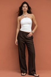 Top de fit ajustado, cuello halter con hebilla frontal en contraste, plisados y lazo amarrable posterior.