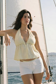 Top corto de cuello halter con lazo amarrable posterior, estampado rayas, escote v con plisados, rib elástico en espalda y lazo amarrable en espalda. Detalle de peplum olanes en bajo.