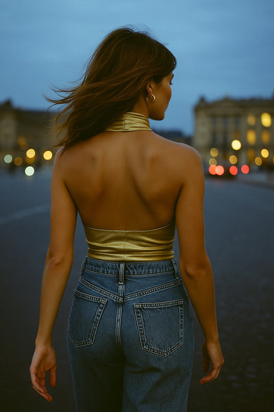 Top halter metálico de fit ajustado, escote fluido, sin mangas y detalles plisados posteriores.