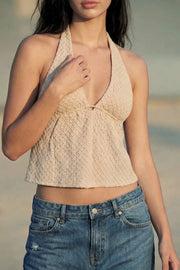 Top corto de cuello halter con lazo amarrable posterior, escote v con plisados, rib elástico en espalda y lazo amarrable en espalda. Detalle de peplum olanes en bajo y textura en tejido.